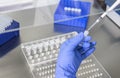 hands of a lab technician with a tube of blood sample and a rack with other samples Royalty Free Stock Photo