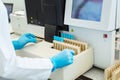 Hands of laboratory assistant loading sample tubes for coagulation test analysis