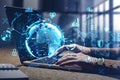 Hands on laptop with double exposure of earth blue hologram
