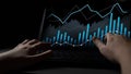 Hands on Laptop Keyboard Analyzing Financial Data and Statistical Graphs with Blue and White Lines on Dark Background Royalty Free Stock Photo