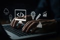 Hands on laptop keyboard with holographic coding and analytics icons, illustrating software development, data, cloud, and digital Royalty Free Stock Photo