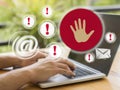 Hands on laptop with stop hand icon and email warning signs on screen Royalty Free Stock Photo