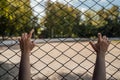 The woman`s hands are gripping the bars. The hands on the lattice are symbolize limitation in something. Woman pulls her Royalty Free Stock Photo