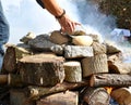 Hands leaving stones called grandmothers on the firewood for the temazcal. Royalty Free Stock Photo