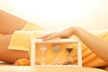 Hands and legs in spa salon with a sandglass Royalty Free Stock Photo