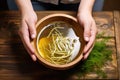 hands lifting a bowl of pho to drink broth