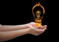hands with light fire icon over. Black background Royalty Free Stock Photo