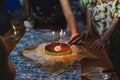 Hands lighting the candles on a celebration birthday cake with family. Royalty Free Stock Photo