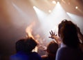 Hands, lighting and excited fans at music festival, crowd watching live band performance with musician on stage