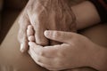 Hands of little Asian kids holding poor elderly grandfather man hands wrinkled skin with feeling care and Love. Father`s Day and