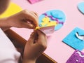 The hands of a little caucasian girl peel off a yellow felt sticker for a blue egg with her fingers Royalty Free Stock Photo