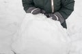 Hands of a little child in warm waterproof mittens playing with snow in cold winter weather