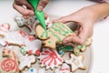 Hands of little girl making traditional Christmas cookies. The child decorates homemade Christmas cookies on a white table Royalty Free Stock Photo