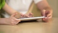 Hands of little girl typing on tablet touchscreen, father and daughter using app