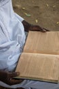 Hands of local Imam Mohammed reading Quran