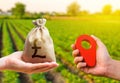 Hands with location pin and british pound sterling money bag. Land market. Estimation cost of plots. Agriculture agribusiness.