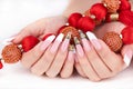 Hands with long artificial white and black french manicured nails and red necklace