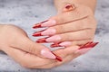 Hands with long red artificial french manicured nails Royalty Free Stock Photo