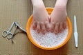 Hands are lowered into foam water. Preparation for manicure.