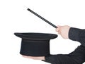 Hands of the magician with magic wand and top hat