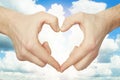 Hands make heart shape against blue sky background Royalty Free Stock Photo