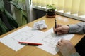 Hands make notes and measurements in an architectural floor plan