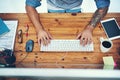 Hands that make things happen. High angle shot of a businessman using a computer at his desk in a modern office. Royalty Free Stock Photo