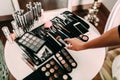 Hands of a makeup artist. Many cosmetics and brushes on a table in the salon. Workplace makeup artist.