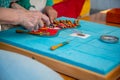 Hands making bobbin lace. Adult helps child learn craft. Colorful lace threads Royalty Free Stock Photo