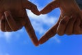 Hands making a heart shape with blur blue sky. Love concept Royalty Free Stock Photo