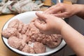 Hands making minced meat cutlets. Preparing meatballs with raw mincemeat