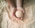 Hands making sphere sand ball by a child at the beach. Play sand