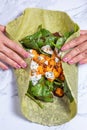 women hands wrapping a veggie wrap