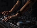 Hands of male dj playing music on modern midi controller turntable digital device for mixing music on events.