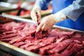 Hands of male worker at meat processing plant close up