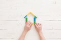 Hands of a man are assembling a house from multi-colored wooden blocks. Early development and education of children. Dad shows his Royalty Free Stock Photo