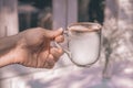 Hands of a man or barista holding cup of hot coffee latte with heart shaped foam art Royalty Free Stock Photo