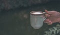 Hands of a man or barista holding cup of hot coffee latte with heart shaped foam art Royalty Free Stock Photo