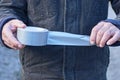 hands of a man in black clothes holding a gray flyer on a roll of reinforced tape