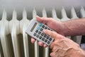 Hands of a man with a calculator figures out the energy costs of an inefficient heating system, concept for home finance,