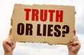 In the hands of a man is a cardboard sign with the inscription - TRUTH OR LIES