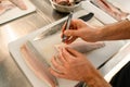 hands of a man chef accurate cleans fish fillets from bones. Royalty Free Stock Photo