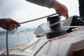 Hands of a man coiling up a rope, the halyard on a sailboat