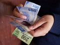 hands of a man counting Mexican banknotes