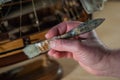 A hands of a man delicately working a model of a miniature ship piece by piece Royalty Free Stock Photo