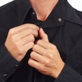 Hands a man fastened the buttons on the black shirt closeup