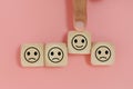 Hands of man finger pointing selection wooden cube blocks with happy emotion icons. personnel selected of corporate.