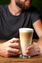Hands of a man with a glass of latte