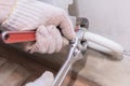 Hands of a man in gloves are installing the heater system in the house and checking pipes by the wrench Royalty Free Stock Photo