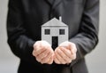 The hands of a man holding a house - insurance and protection concept Royalty Free Stock Photo